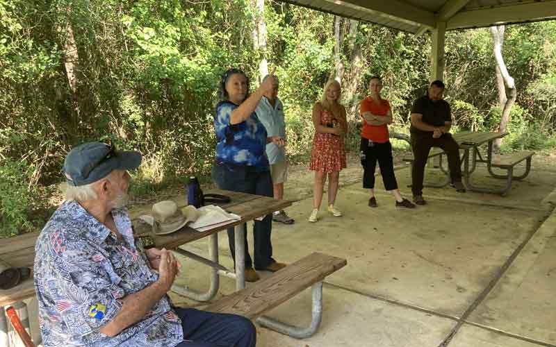 Photo of people outside listening to a presentation