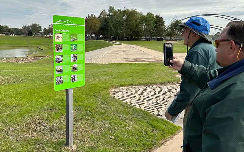 Man taking a picture of a sign