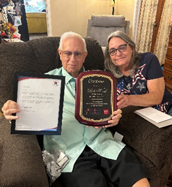 Photo of Mr. Bob Wood showing off 2 award plaques