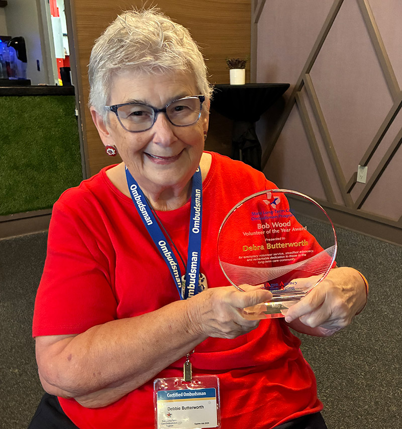 Recipient Debbie Butterworth holding the Bob Wood Volunteer of the Year Award